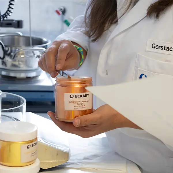 Close up of a cosmetic chemist transferring effect pigments